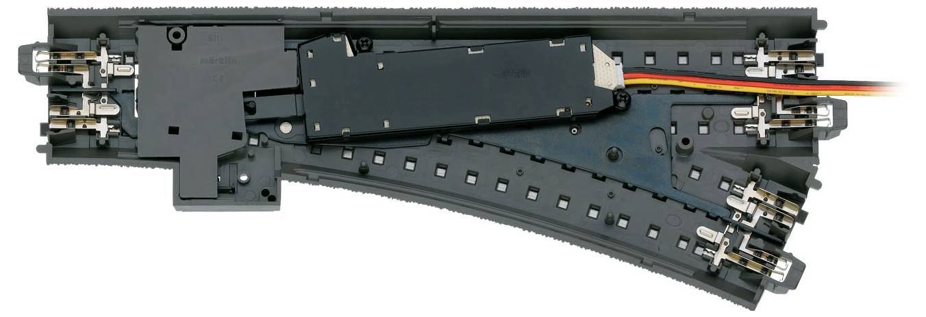 Model railway point with electrical connections and switch; enables changing track directions for model trains.