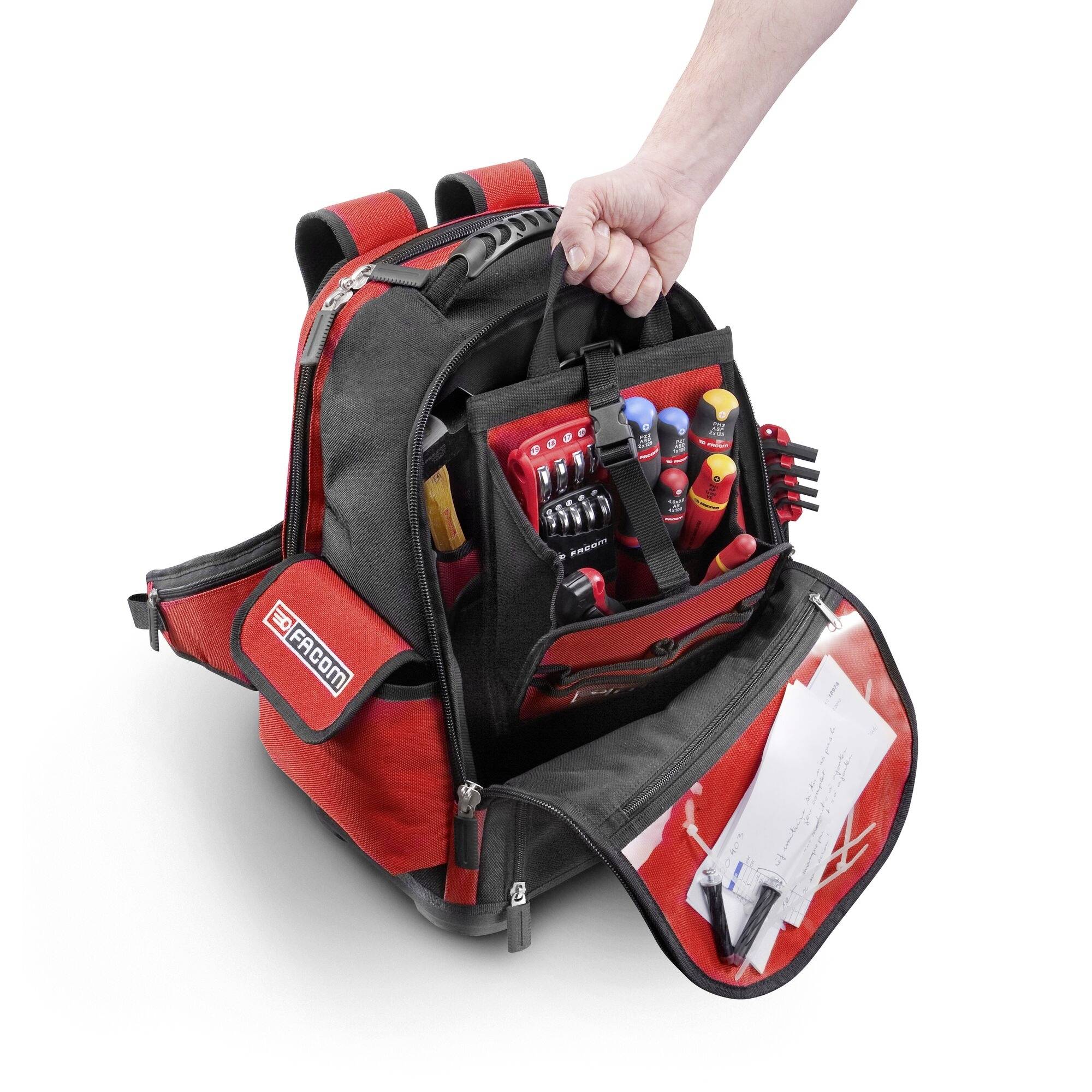 An opened, red tool rucksack with a variety of tools, including screwdrivers and pliers, and a hand-held strap.