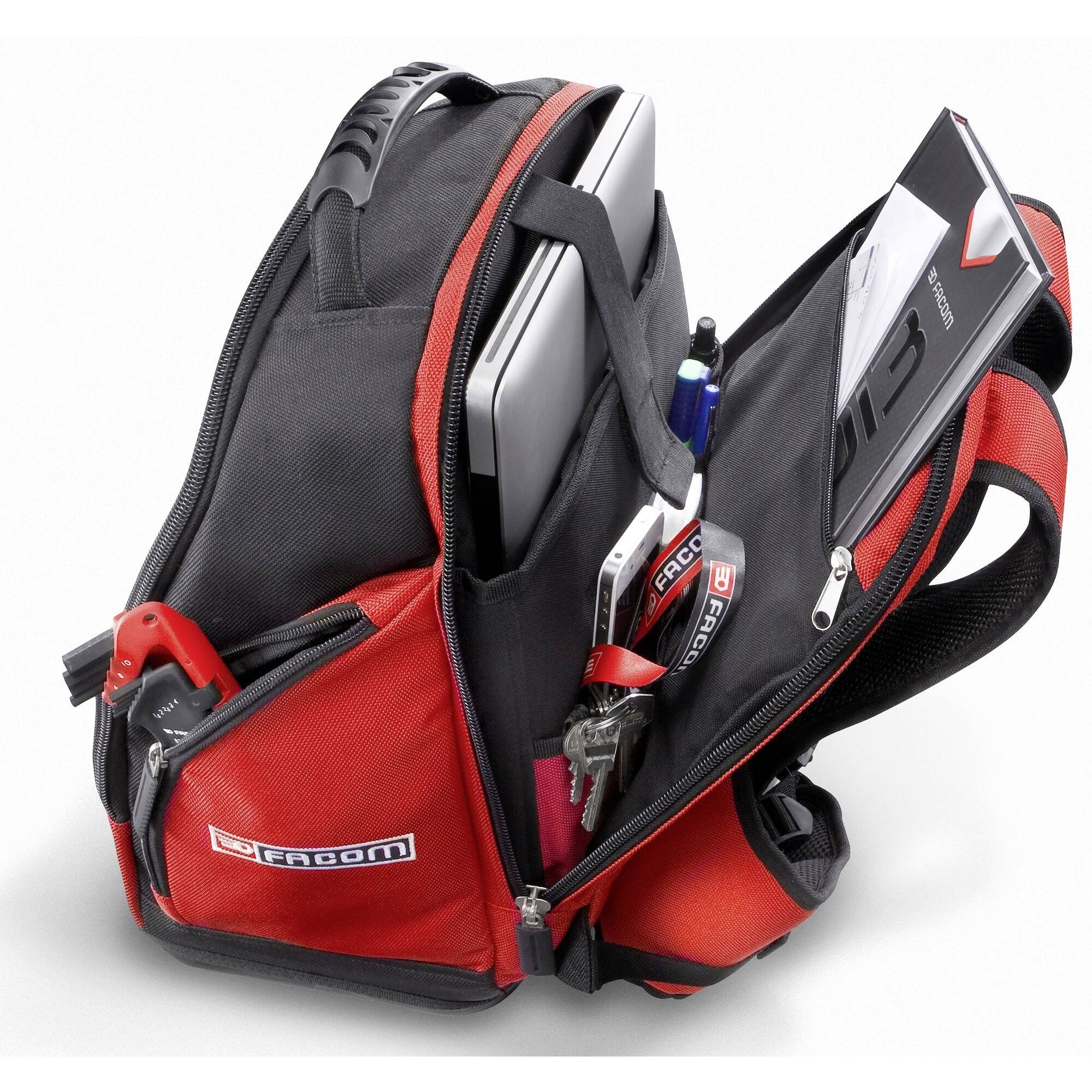 An open rucksack containing a laptop, a notebook, pens, and keys, all neatly organised in separate compartments.