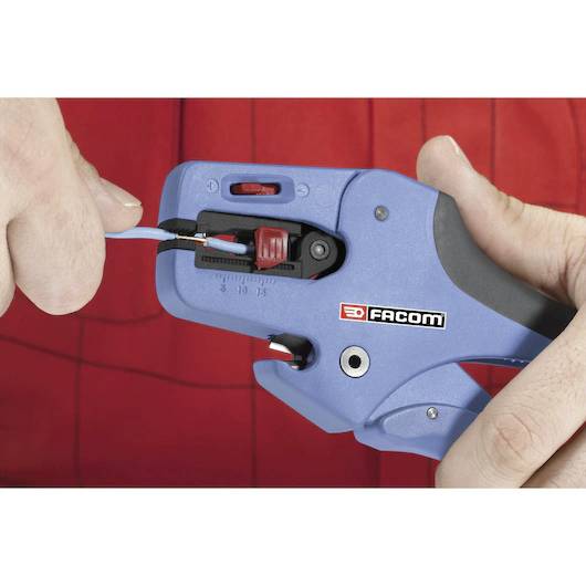 'Hands using a blue tool to strip insulation from a wire. A red background highlights the action.'