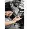A person is working with a spanner on a motorcycle engine, with details of the engine visible.