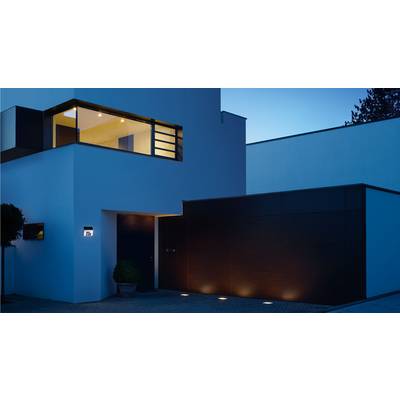 Modern, white villa at night with illuminated windows and entrance area. Elegant, minimalist design with clean lines.