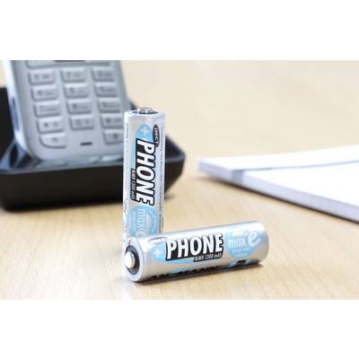 Two AA batteries with 'PHONE' printed on them, one standing upright and the other lying down, in front of a cordless telephone on a desk.
