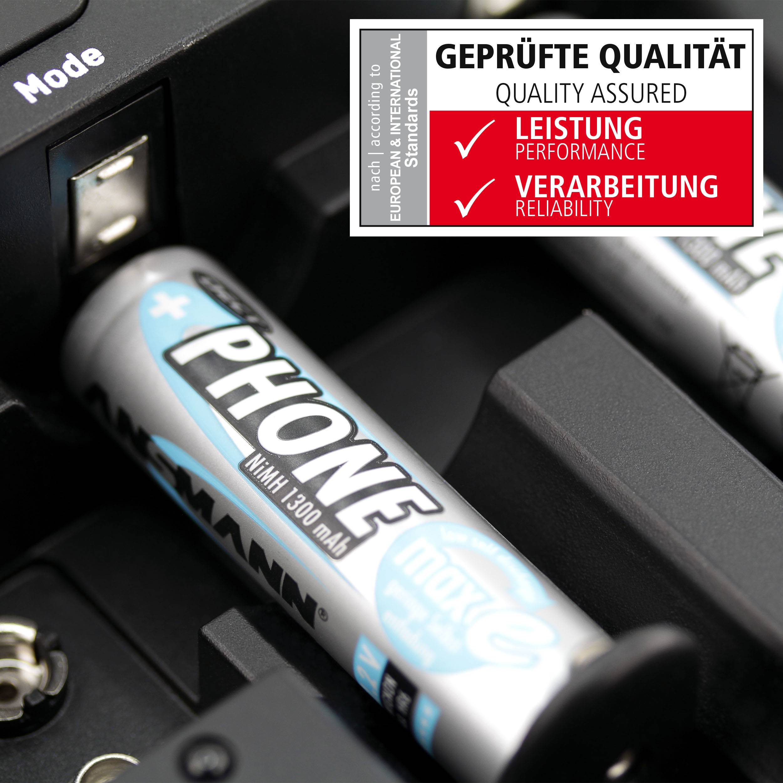 A close-up of a battery charger with batteries inserted. A label shows the words 'TESTED QUALITY' with categories 'Performance' and 'Workmanship'.