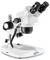 A binocular microscope with fixed lenses, rotatable knobs and a white stand. Suitable for laboratory examinations, brand 'Kern'.