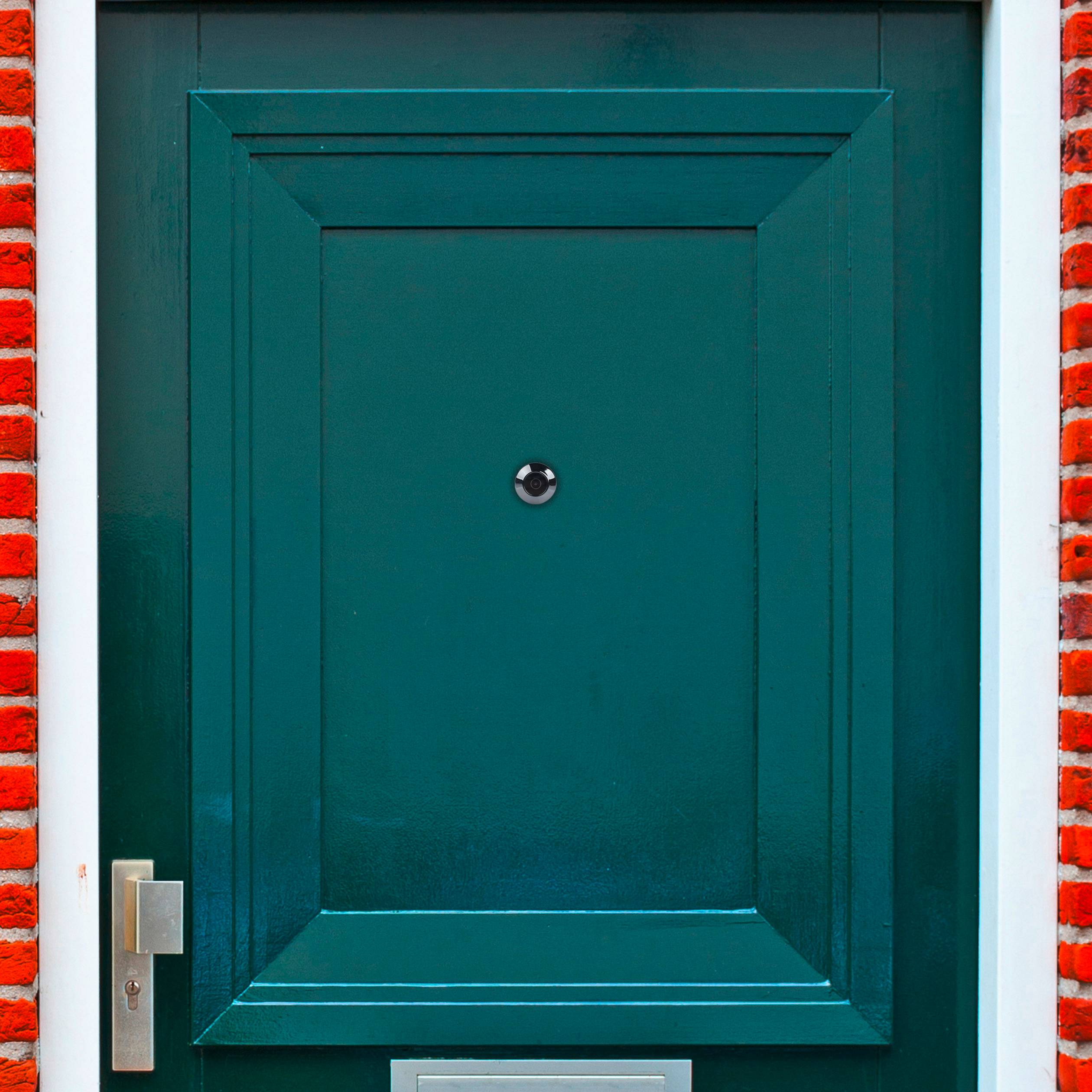 Green front door with a silver door handle and letterbox, surrounded by a red brick wall.