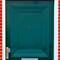 Green front door with a silver door handle and letterbox, surrounded by a red brick wall.
