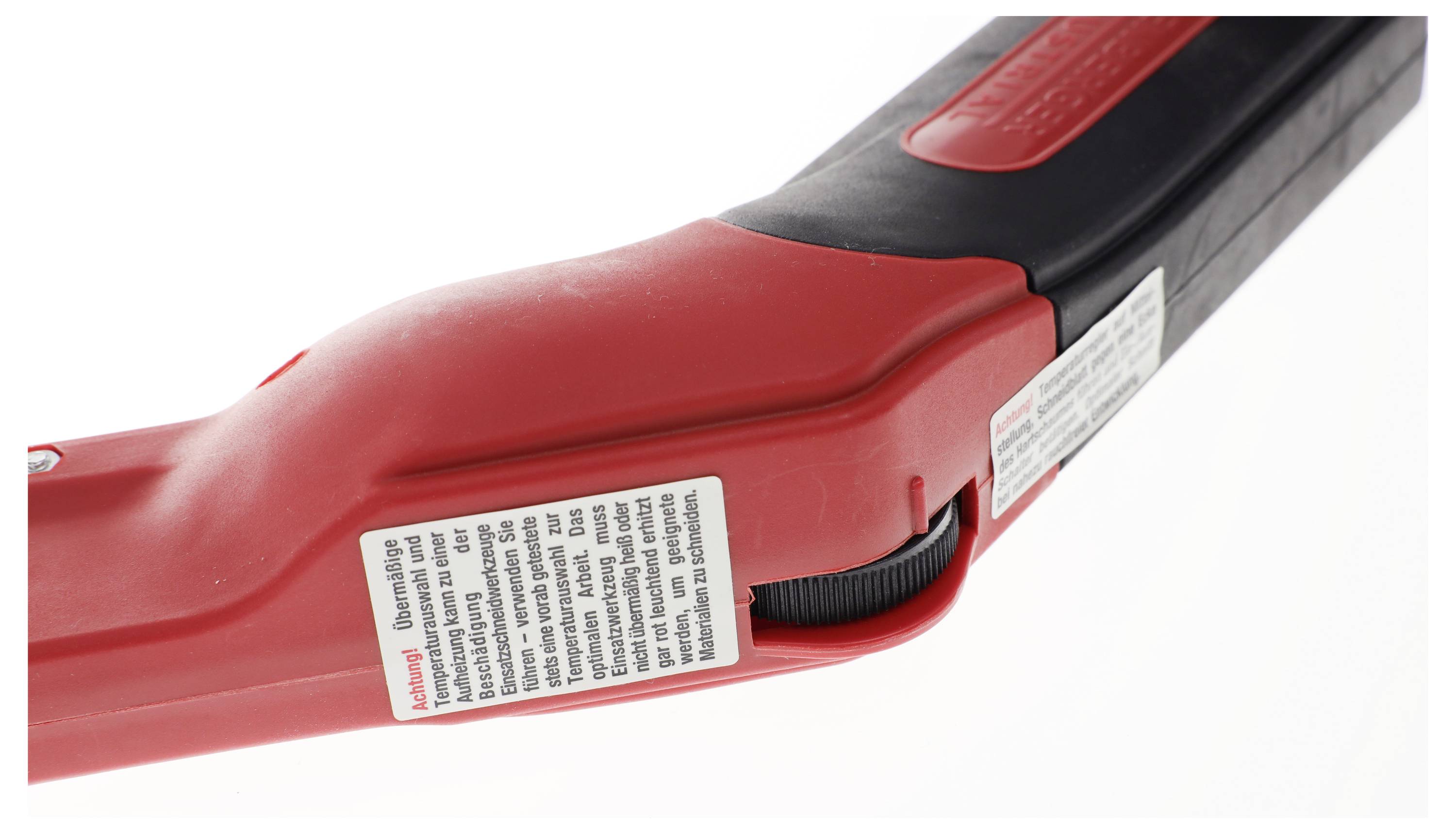 Red and black handle of a tool, with a white label containing warning notices.