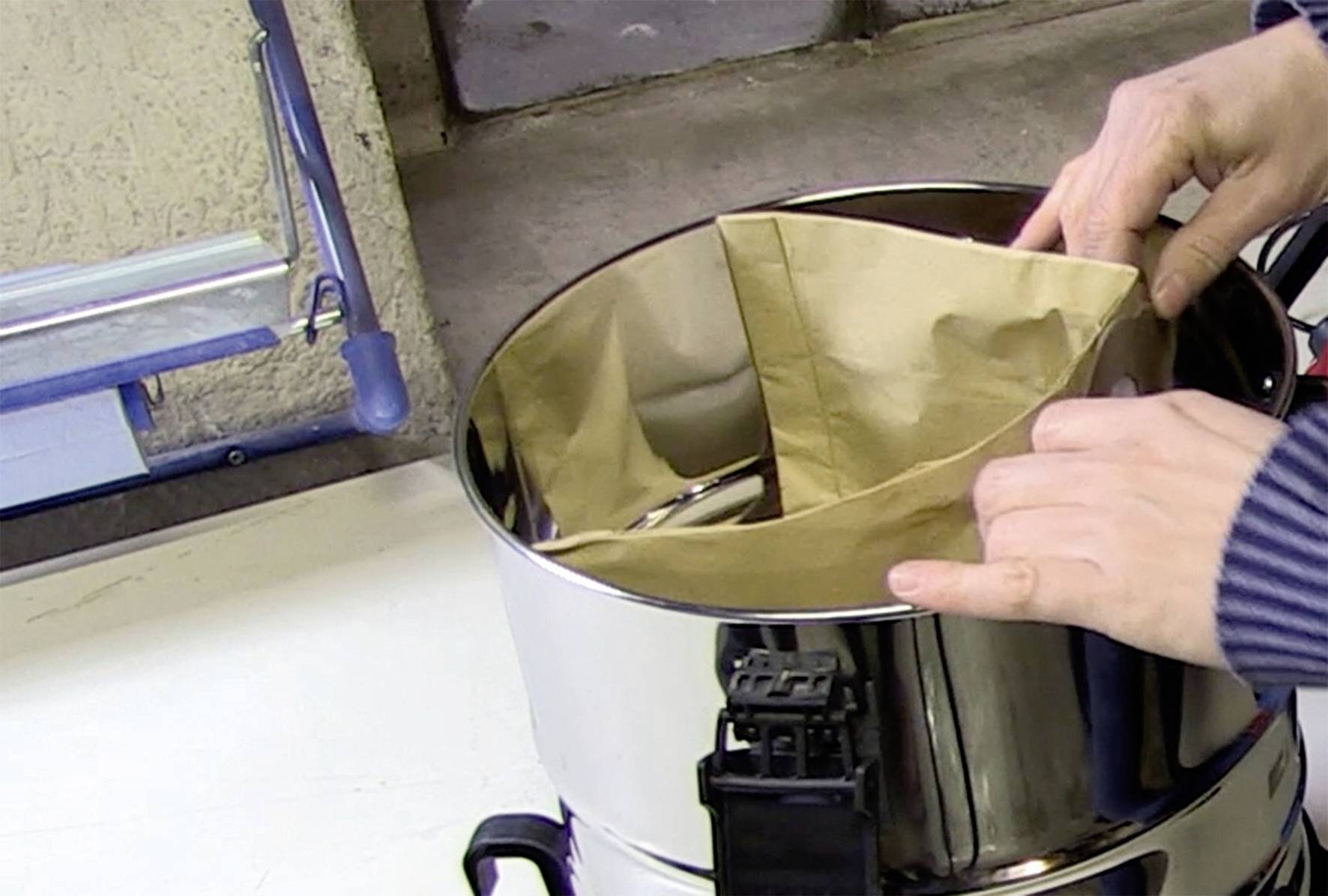 'A person places a paper filter in a round, metallic device.'