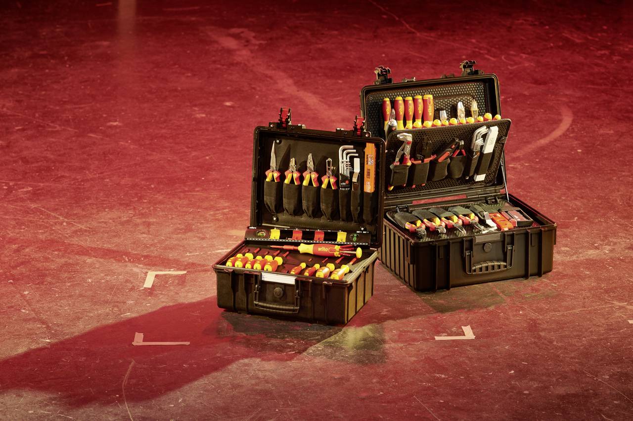 Two open toolboxes with various tools on a red floor. A shadow is visible in the background.