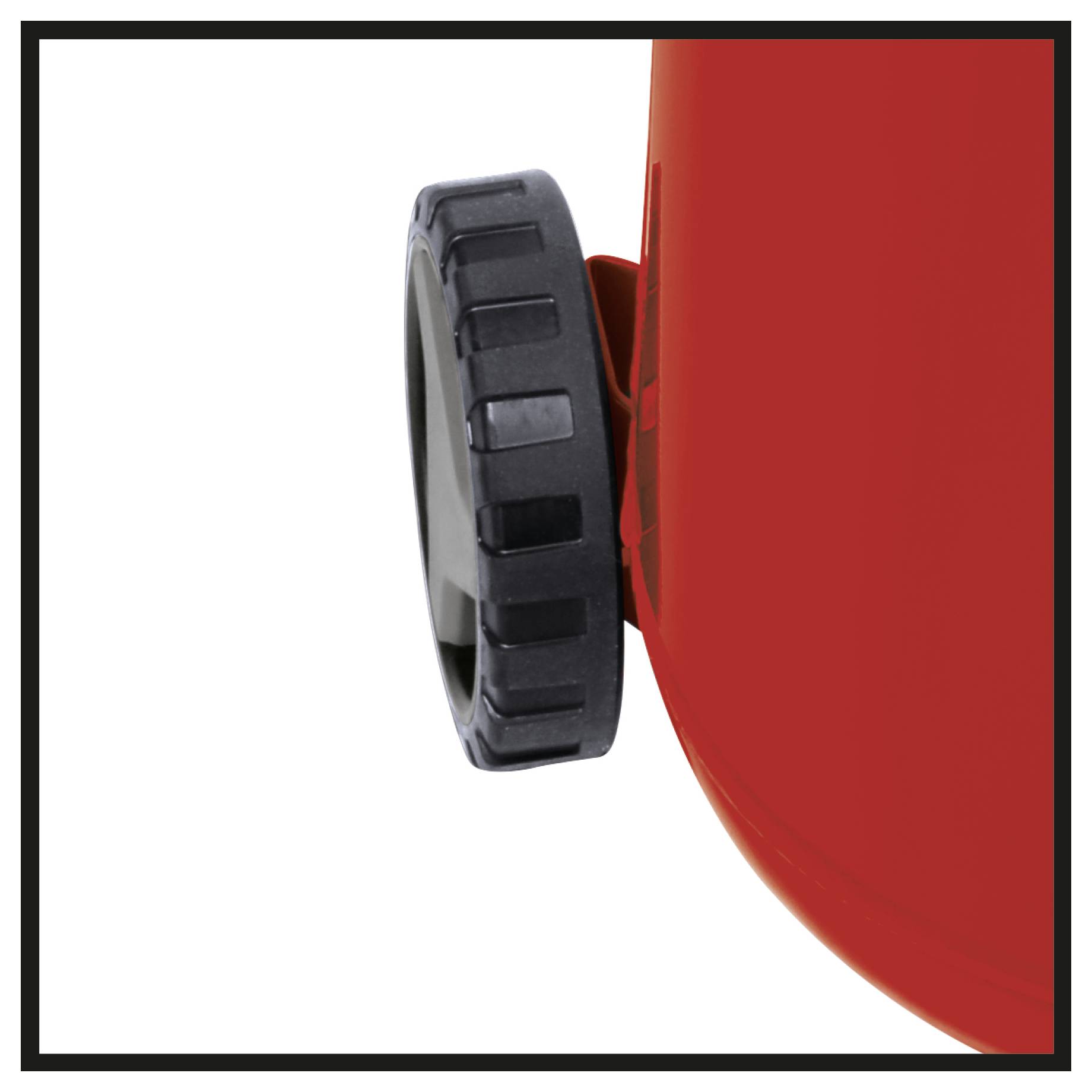 Close-up of a red machine or container with a black ridged adjustment knob on the side.<br>