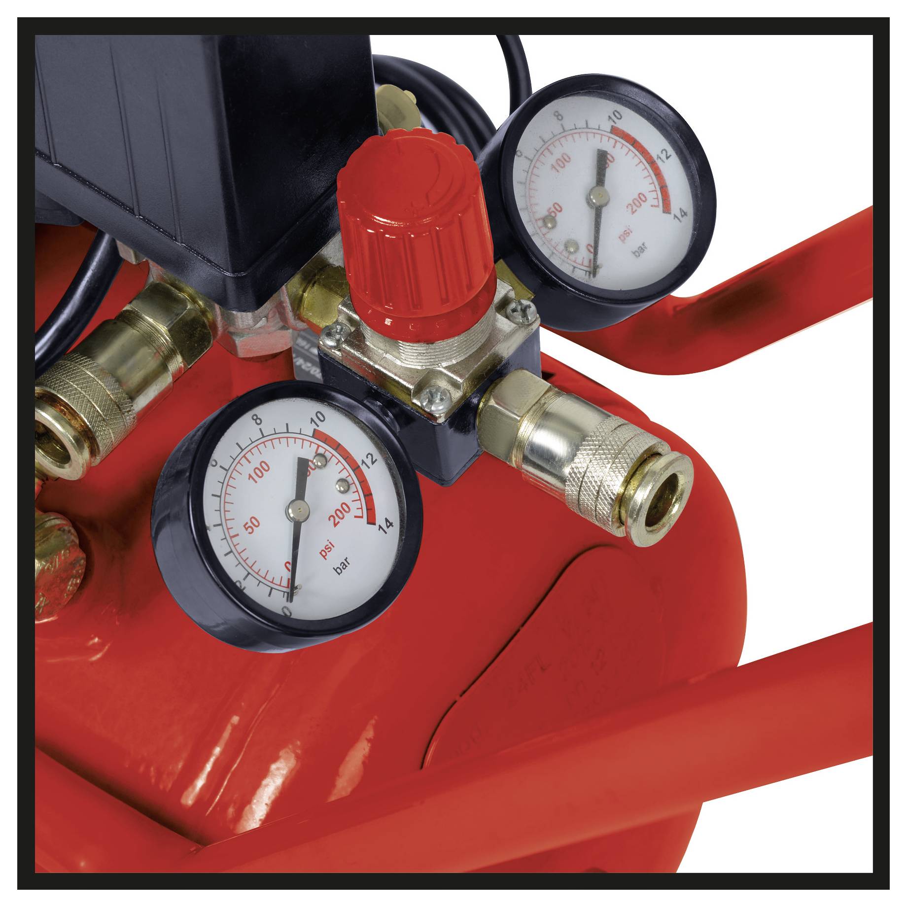 Close-up of an air compressor pressure regulator with two gauges and a red adjustment knob on a red tank.