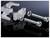 Two screws with washers, alongside a two-part metal tool with threading, on a glossy black background.
