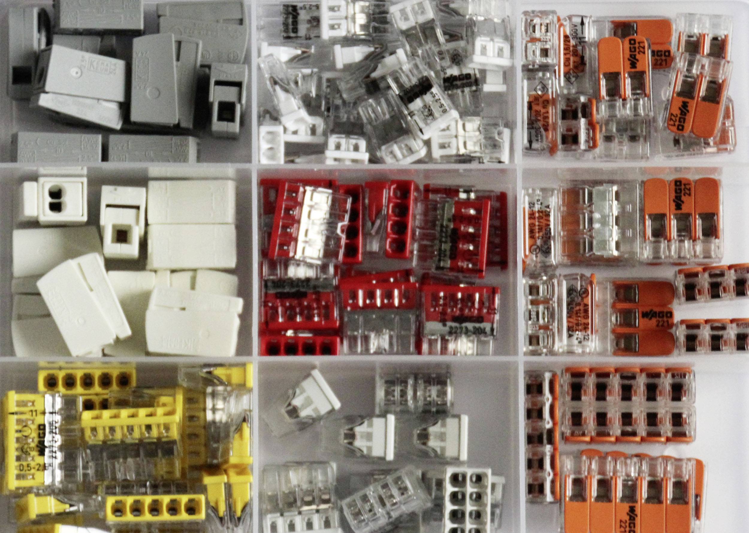 Various connectors in an organised compartment: grey, red, yellow, and transparent variants, each sorted into separate sections.