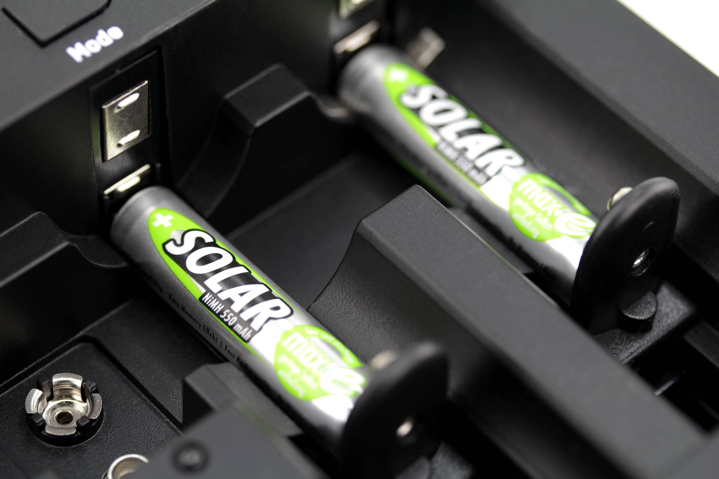 Two rechargeable batteries with the label 'Solar' are inserted in a charger. Two charging slots remain unused.