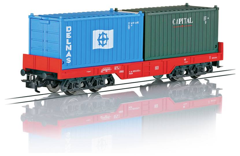 A model freight train car on tracks with two containers. The blue container reads 'DELMAS' and the black container reads 'CAPITAL.'