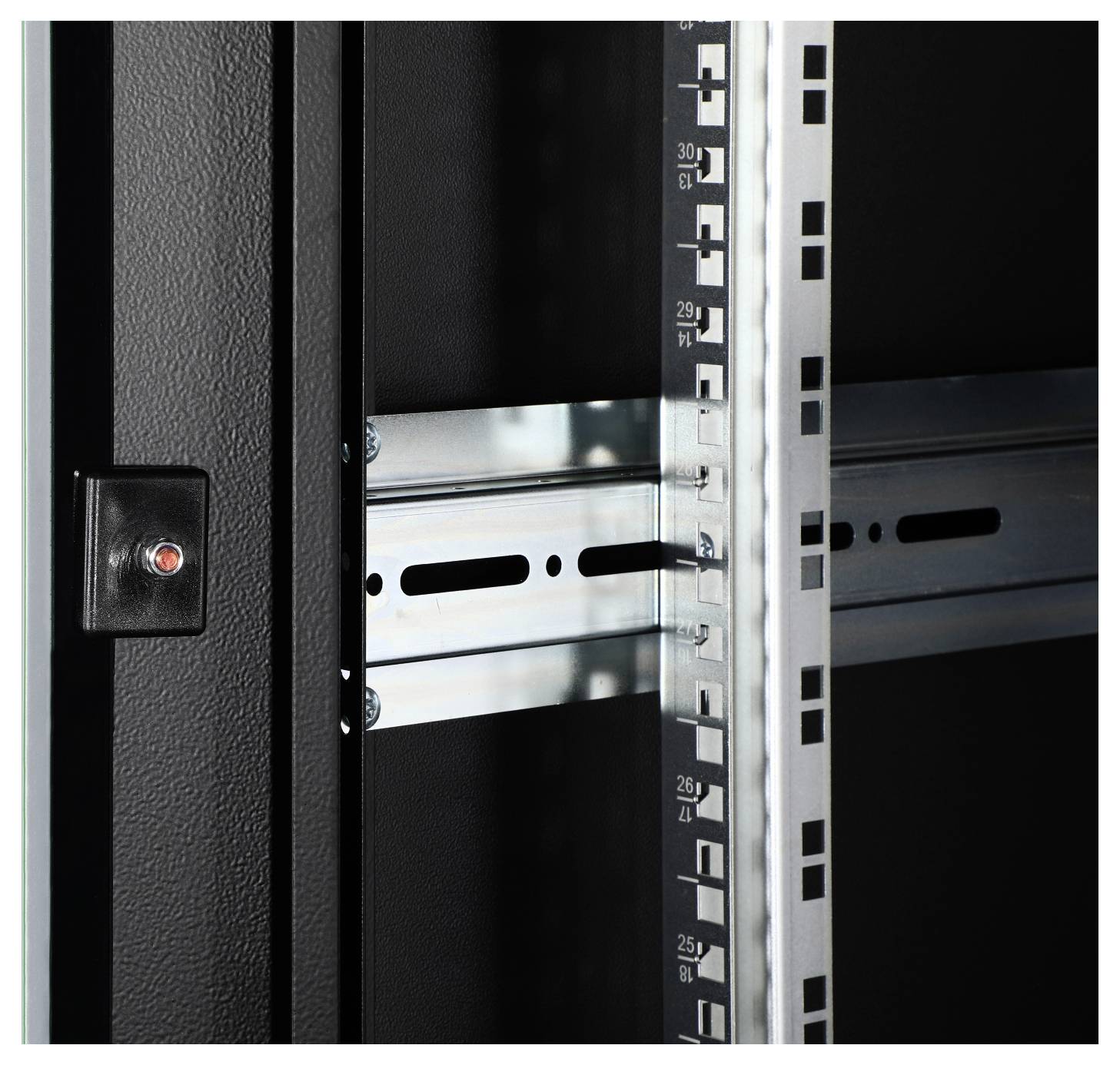 Close-up of a black metal enclosure with rails and numerical markings, likely for mounting electronic equipment.