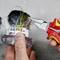 A tradesman is installing a power socket, using pliers to crimp the cables that are emerging from the wall.