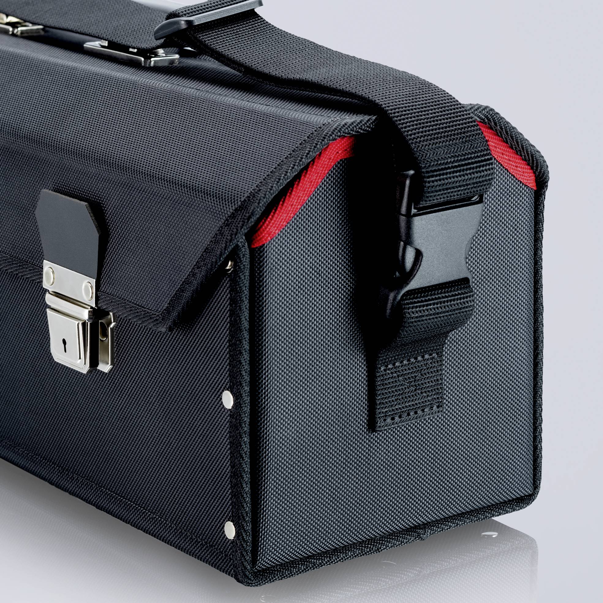 Black fabric tool bag with reinforced edges and metal fastenings, on a grey background.