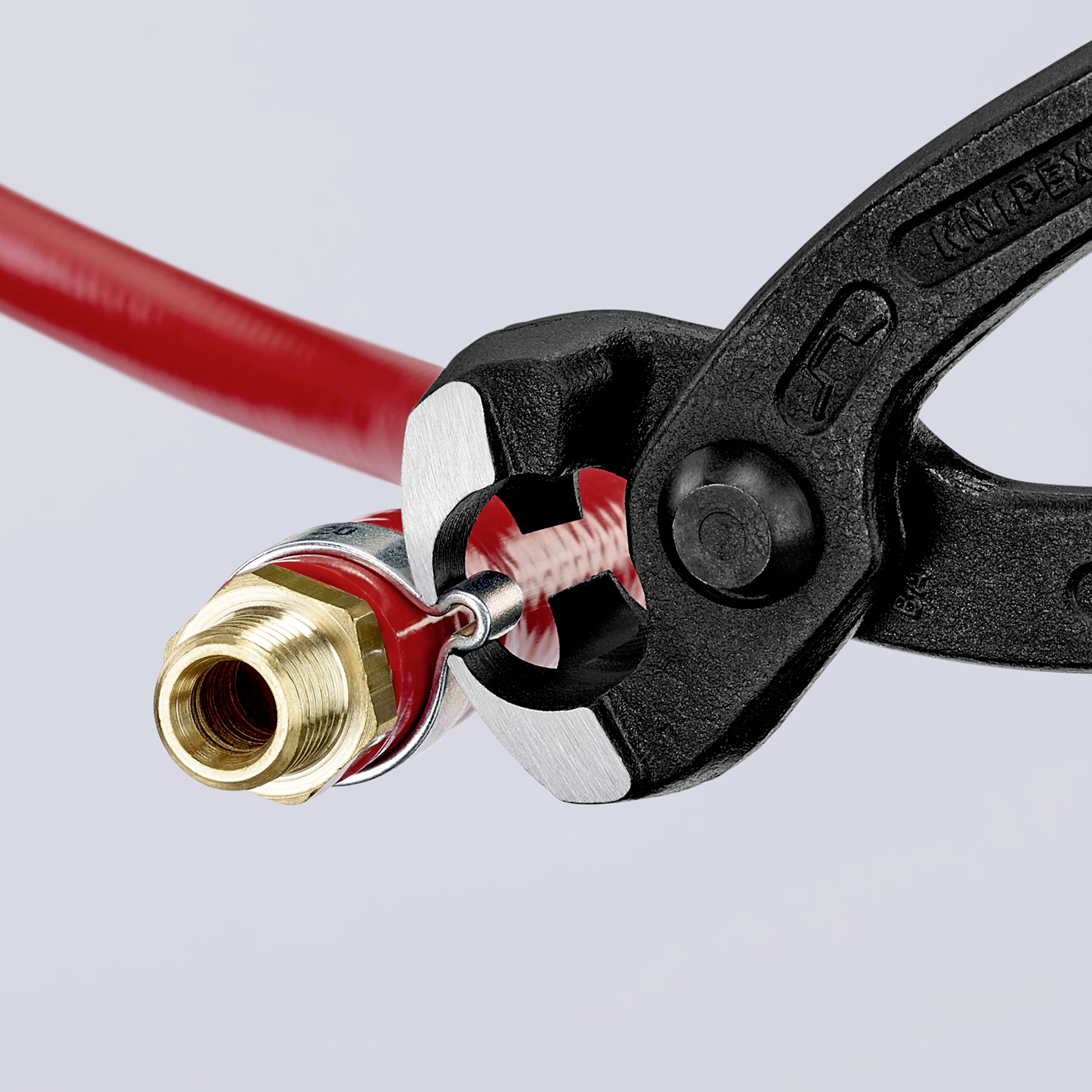 A red cable is held firmly with pliers on a golden, metallic connector that serves for connection.