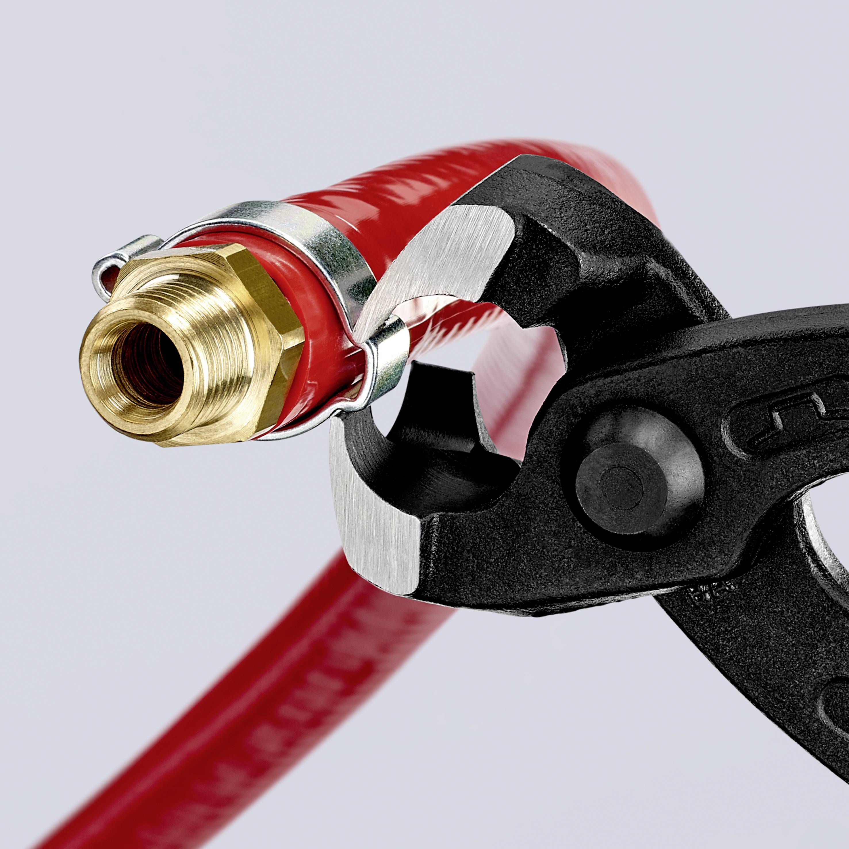 Black spanner grips the end of a red water hose with metal fitting, against a neutral background.