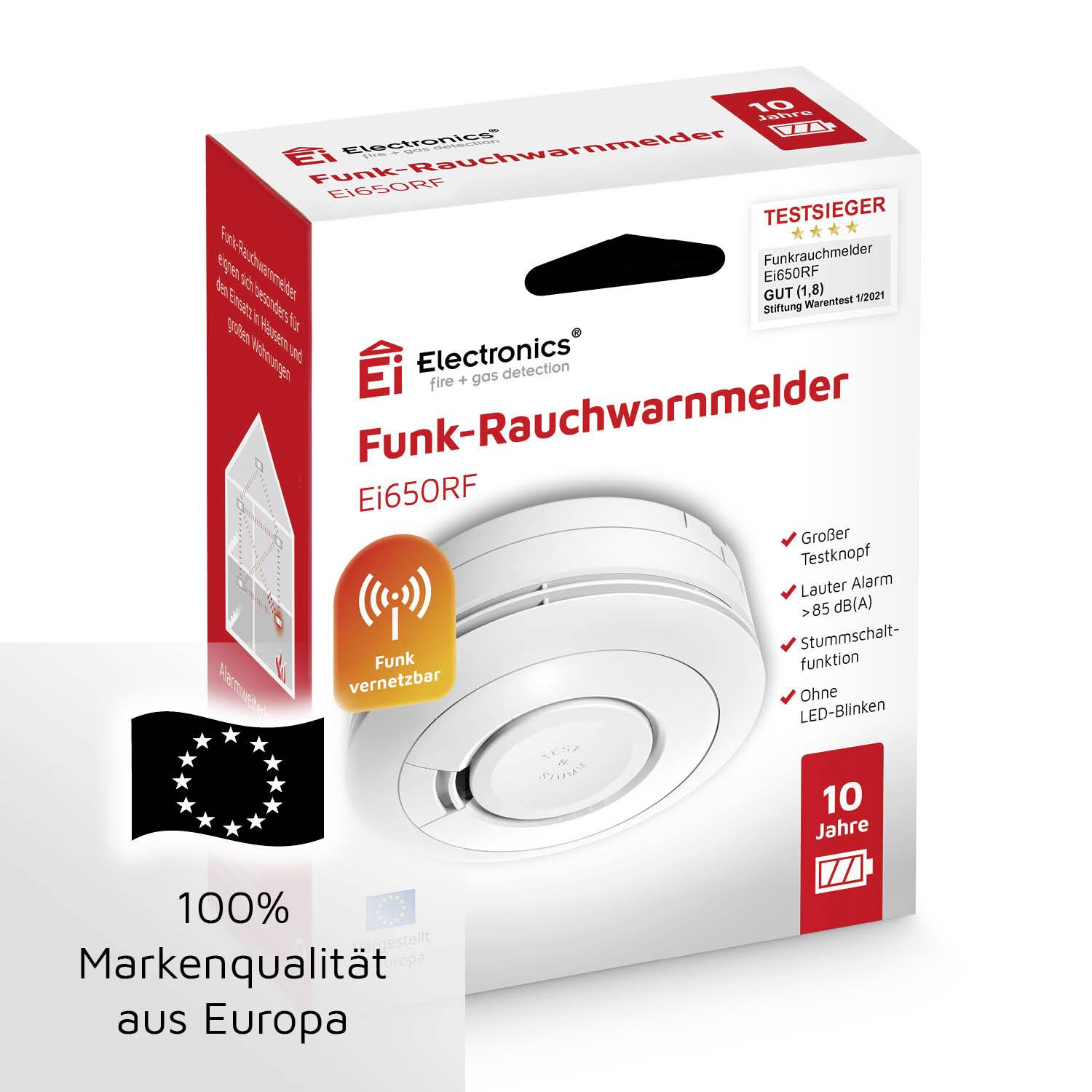 A red product packaging of a wireless smoke detector with a winner's seal. Text: 'Wirelessly networkable', '10-year guarantee', '100% brand quality from Europe'.
