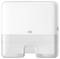 White Tork paper towel dispenser with translucent lower cover and front lock, shown against a plain background.