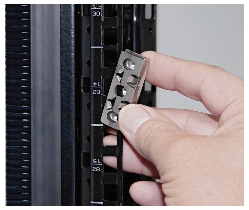A hand is holding a small metal part next to a scale ranging from 15 to 39.