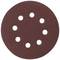 A round piece of sandpaper with eight evenly spaced holes arranged in a circle. Brown, granular surface.