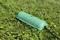 Green cable protection on wet grass, protects electrical cables from moisture and weather conditions.