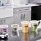 Several transparent containers on a kitchen worktop, filled with chopped vegetables and cheese, labelled 'MON 3/6'.
