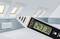 An infrared temperature measuring device displays '24.3 °C'. Background: Loft with sloping roof windows and radiator.
