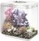 A rectangular aquarium with colorful coral, rocks, and sea decorations inside; water filled to the brim at the top.
