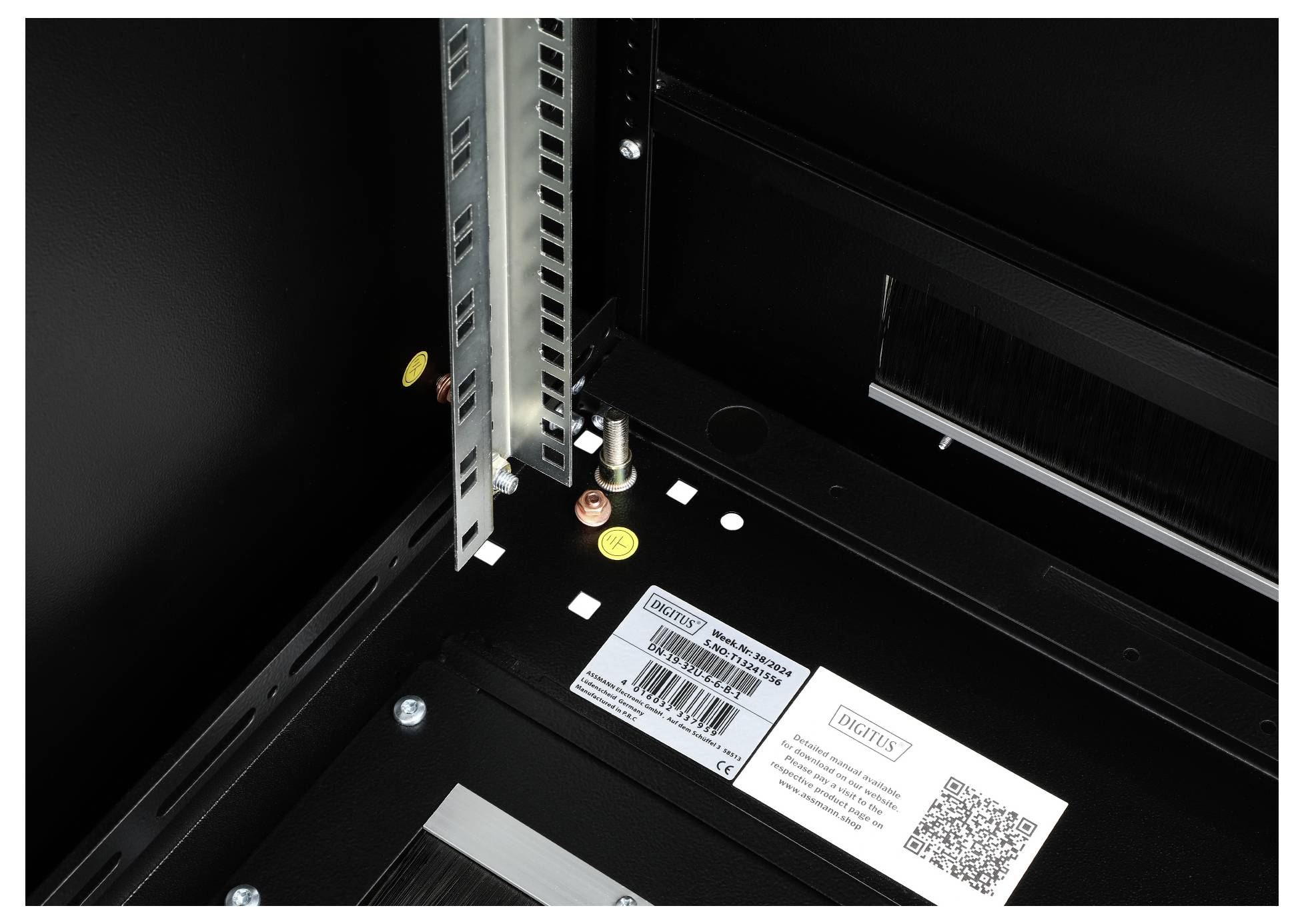 Metal strut with coloured markings and a screw in a black housing, label with barcode and QR code on the side.