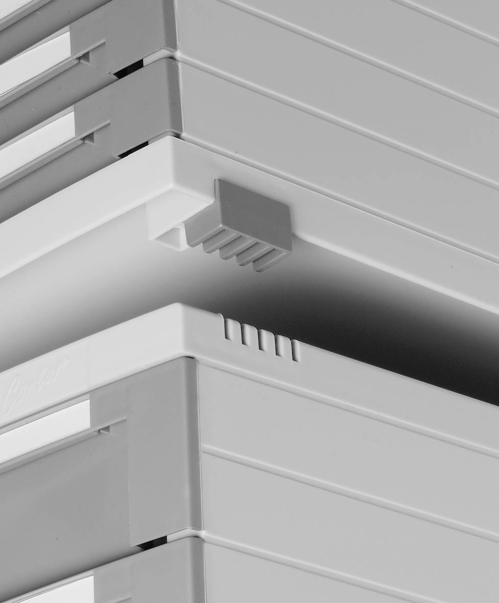 Stacked, grey plastic containers with interlocking corners, ensuring stable storage.