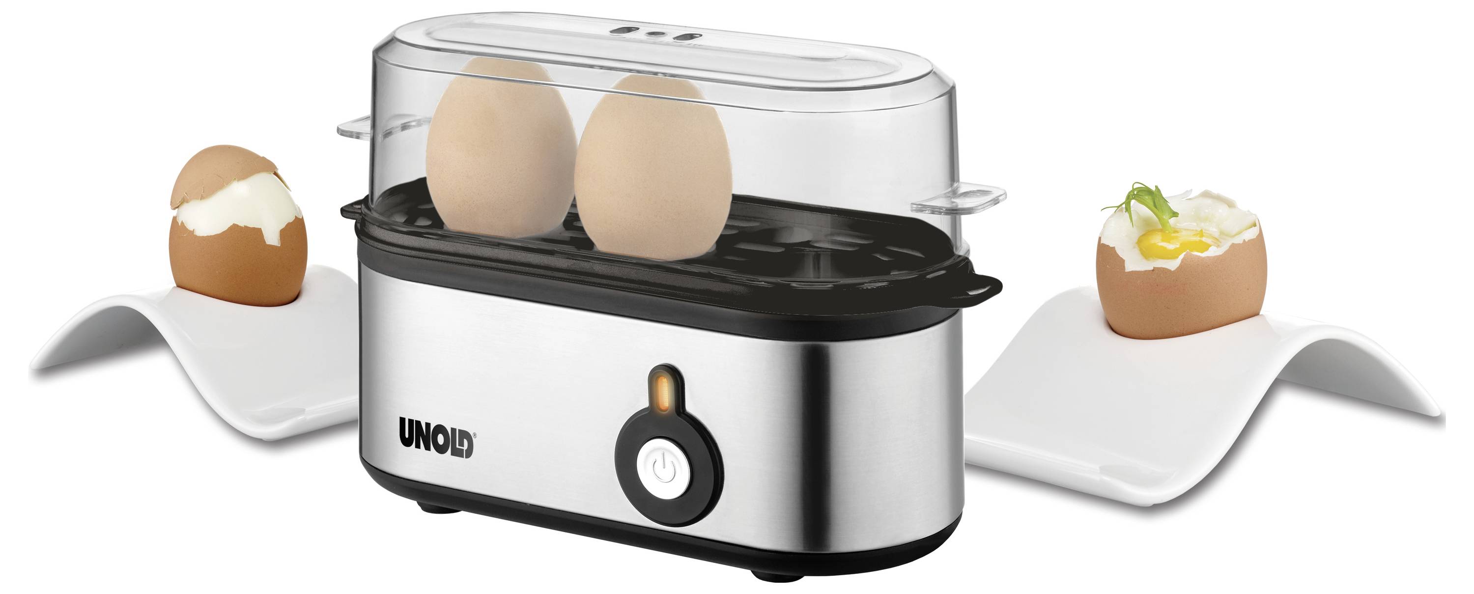 Egg cooker with two eggs displayed in it, placed between two egg cups with cooked eggs, one soft-boiled, one with herbs on top.
