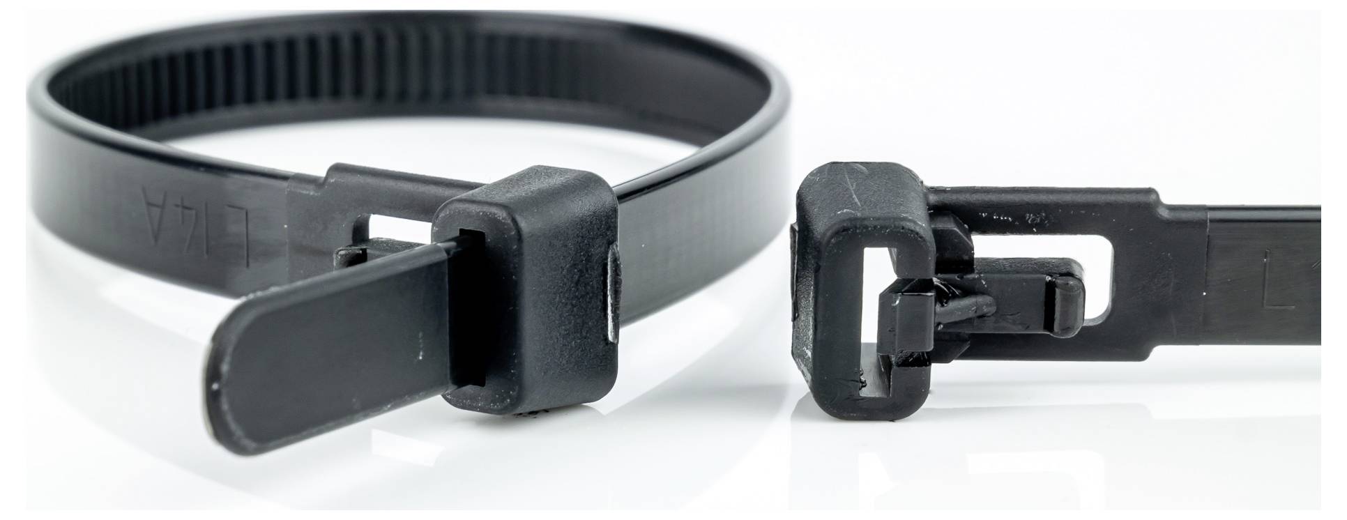 A close-up of two black cable ties, one looped and fastened, the other unfastened, showcasing the locking mechanism and ridged texture.