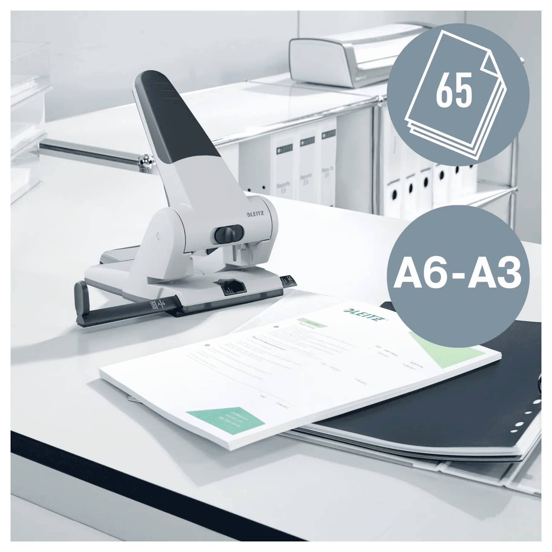 'A white office hole puncher on a desk can punch A6 to A3 size paper, holds up to 65 sheets. Background features office storage.'