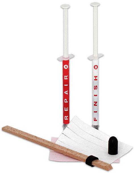 Two red syringes labelled 'Repair' and 'Finish', a wooden stick, sandpaper, and a small black repair tool.