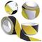A roll of black and yellow striped anti-slip tape. Insets show the tape being peeled back to reveal adhesive backing.