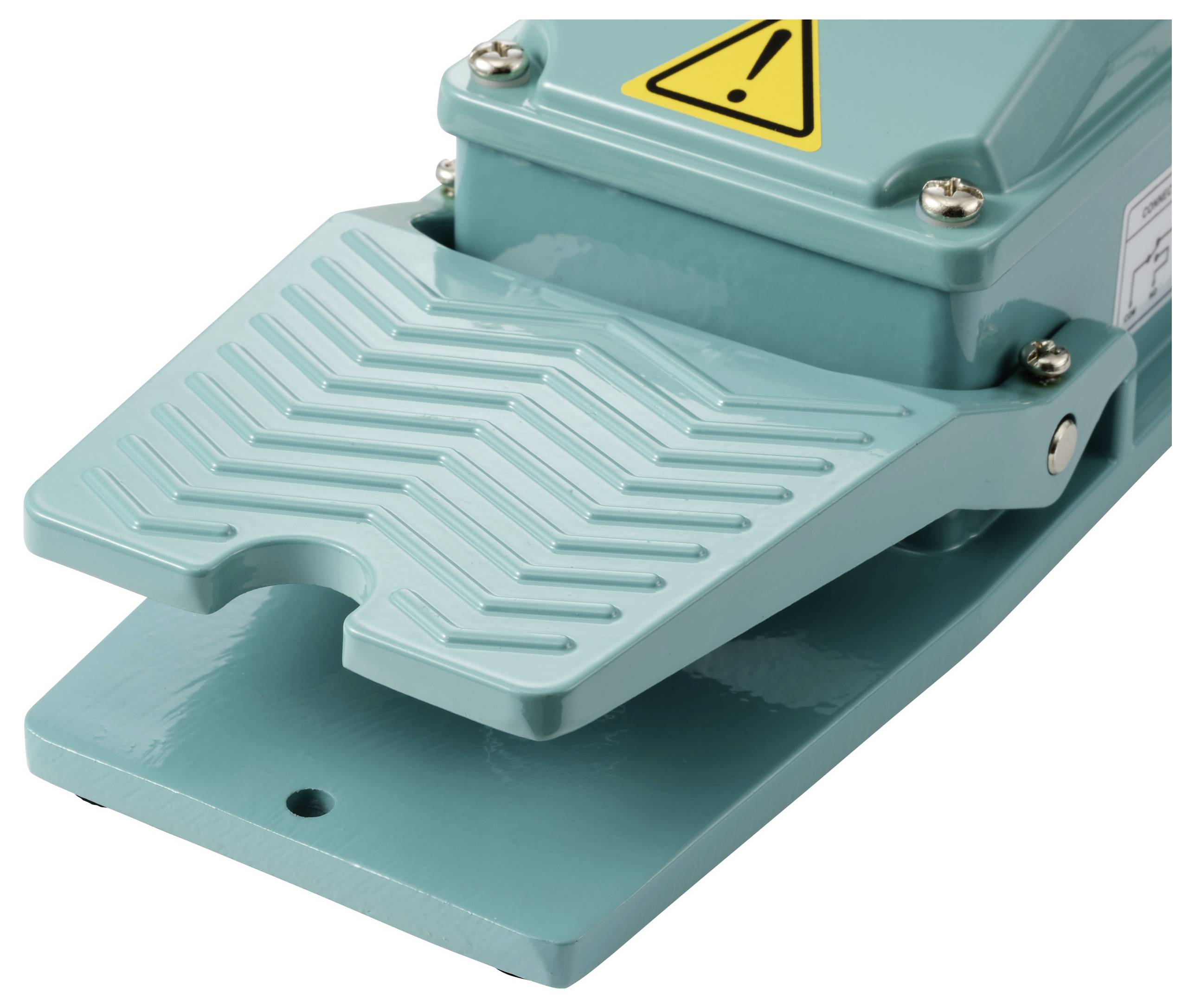 A green foot pedal with a yellow warning label on the top surface.