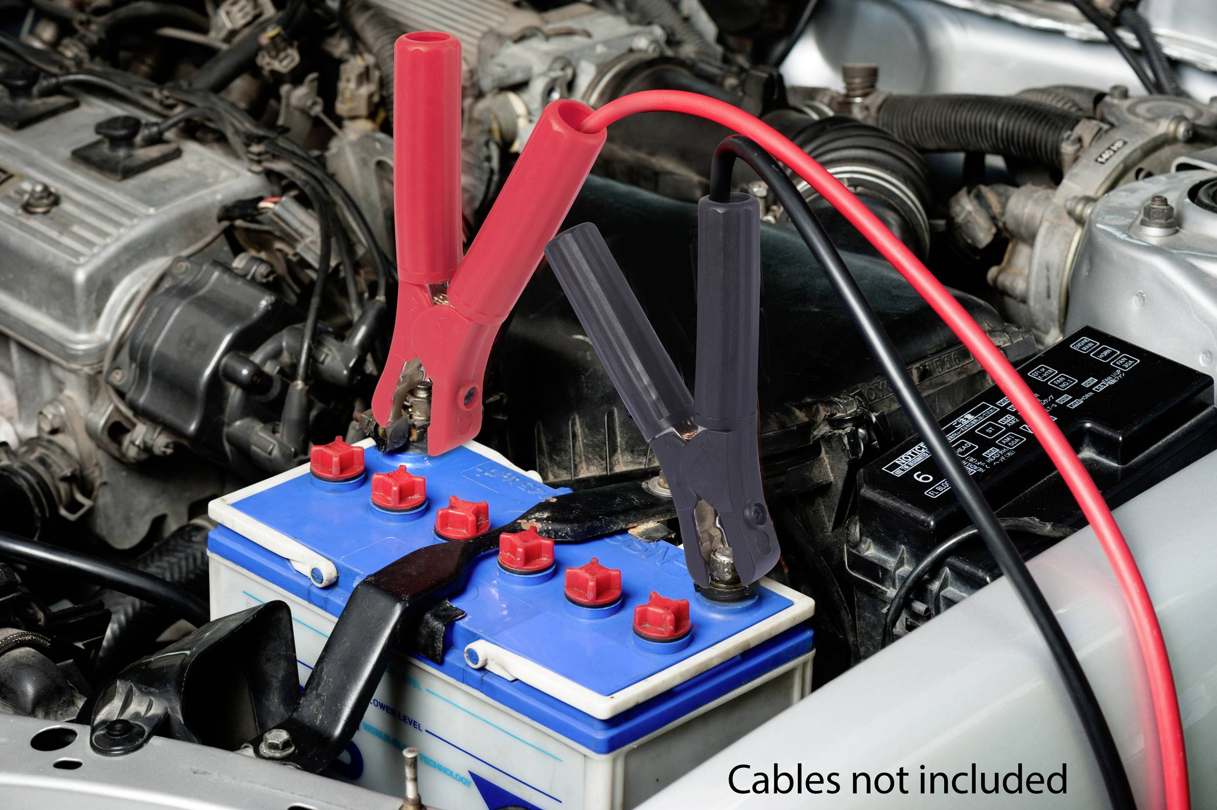 'Car battery connected with red and black terminals. Text 'Cables not included' bottom right.'
