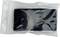 A black object in a clear plastic bag, possibly an electronic device or accessory, against a white background.