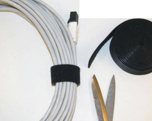 'A pair of scissors, a rolled-up cable reel, a hook and loop fastener, and a self-adhesive tape roll on a white background.'