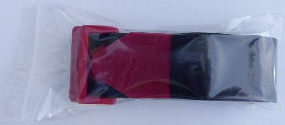 A packaged elastic fitness band, half red, half black, rests in a transparent plastic packaging on a white background.