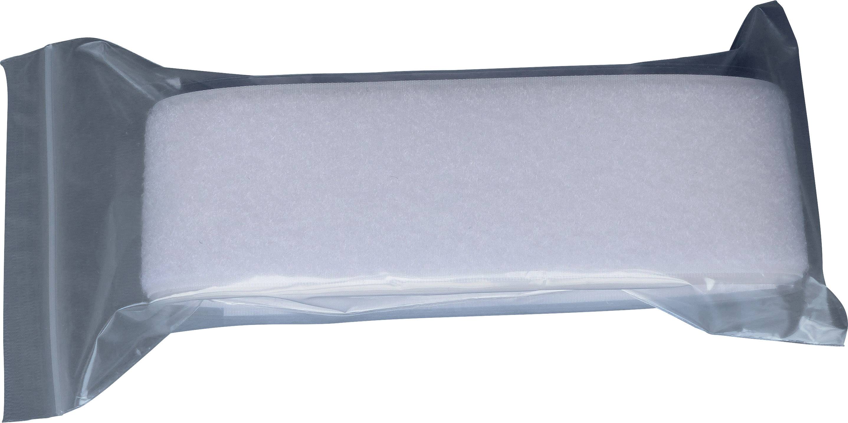 A white cleaning sponge in a transparent packaging, lying on a flat surface.