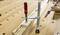 A G-clamp secures a piece of wood to a workbench. Hands are holding tools for assembly.