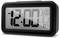 A digital alarm clock displaying '12:00 AM'. Alarm set for '6:00 AM', with date '11/1' and temperature '14.5°C'. Black frame.