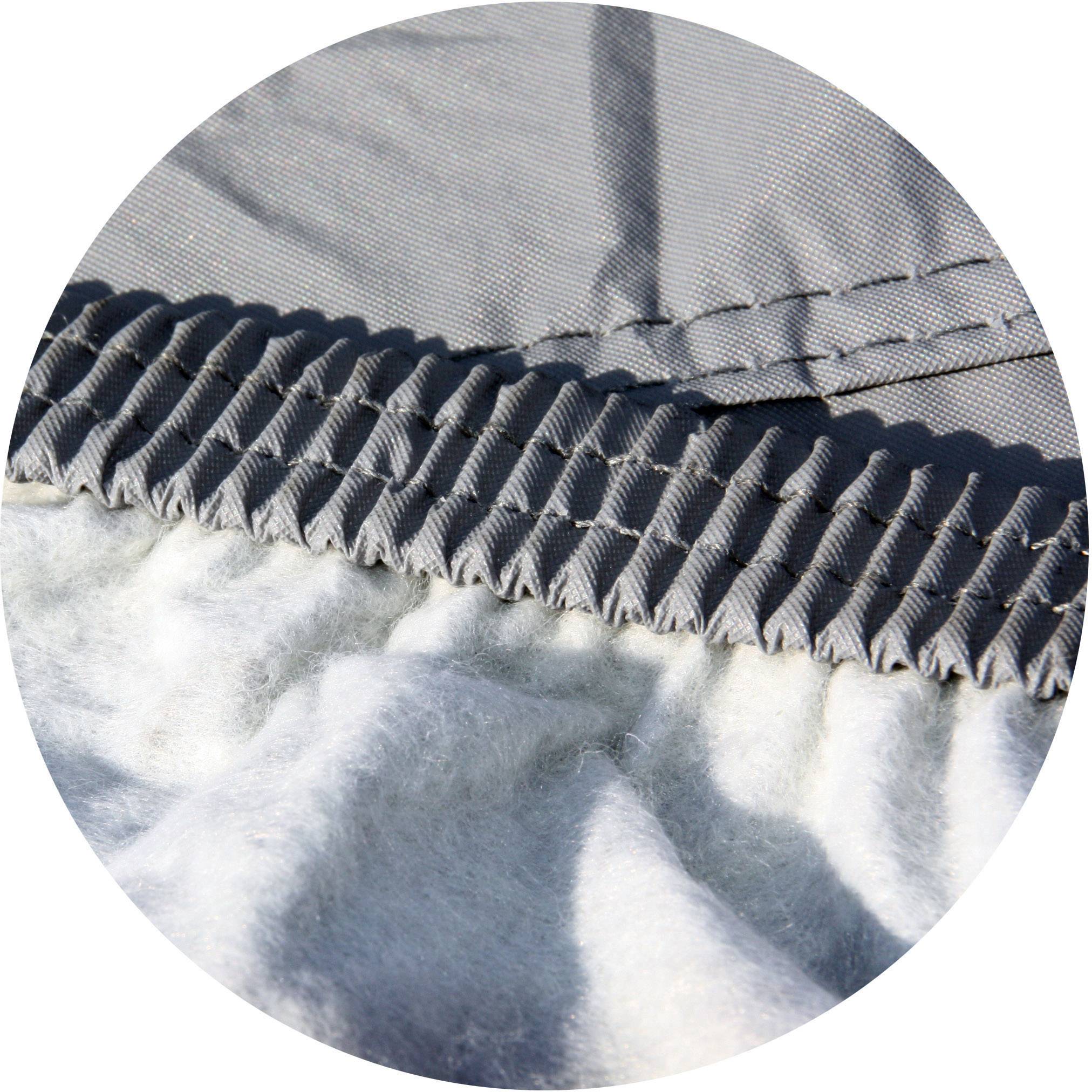 Close-up of a grey, elastic fabric with a ribbed cuff on a soft, light grey surface. Texture and material in focus.