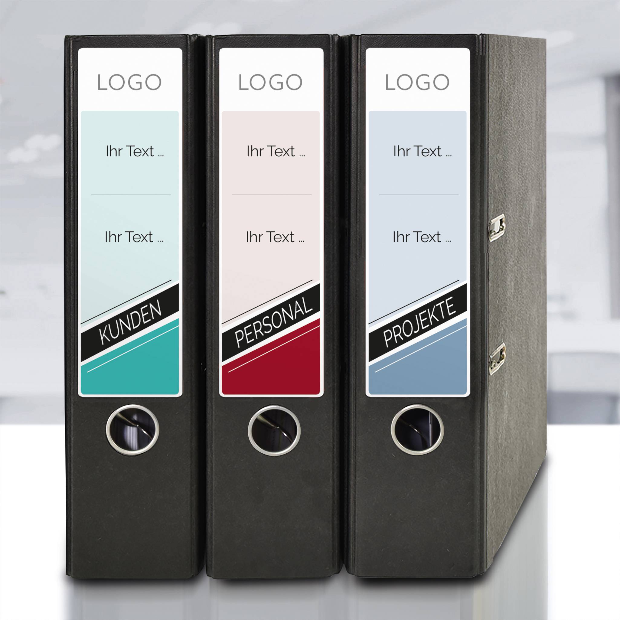 'Three black ring binders side by side, labelled "Customers", "Staff" and "Projects", standing on a white table.'